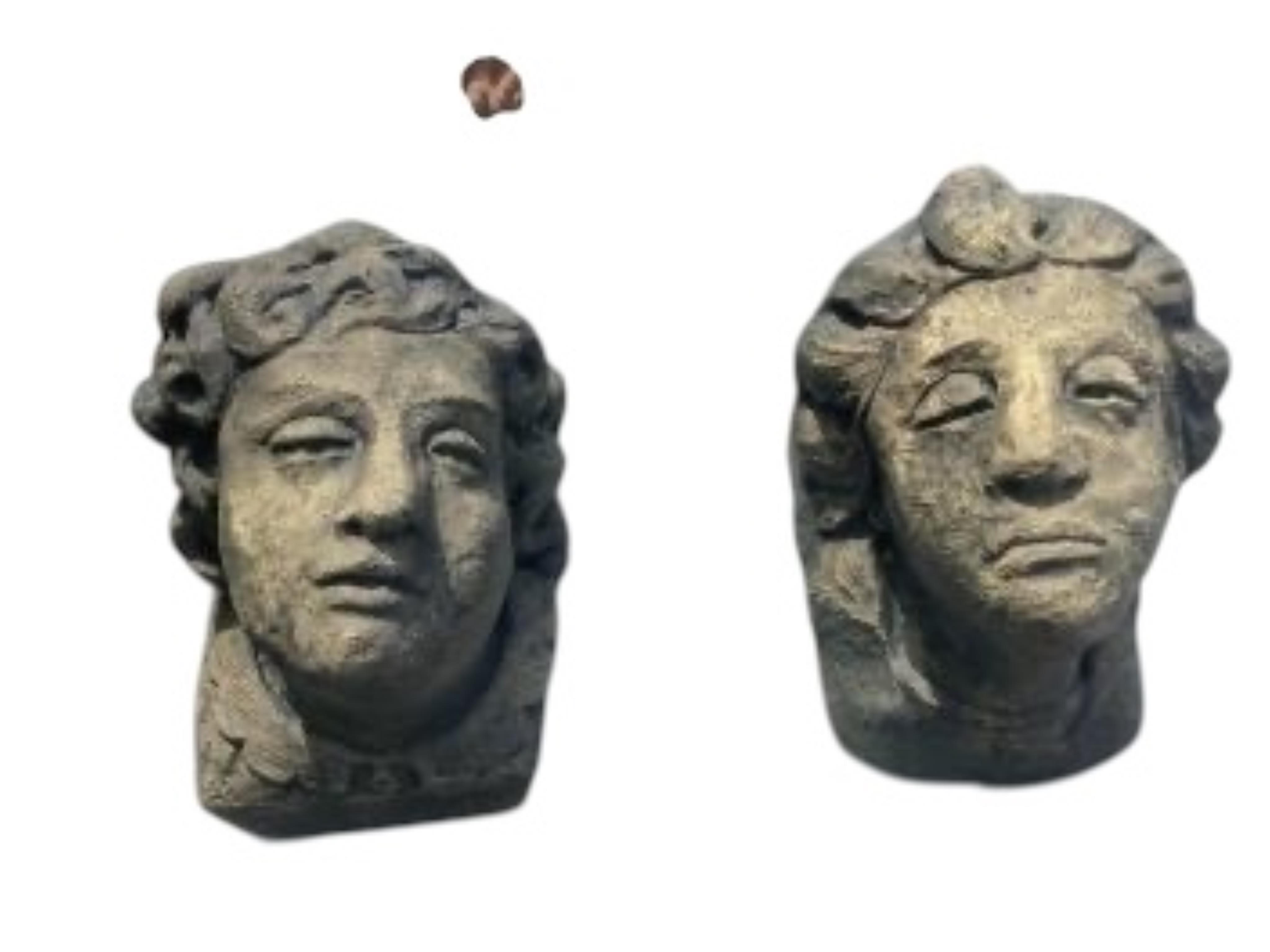 A pair of cast stone mask corbels, height 21cm